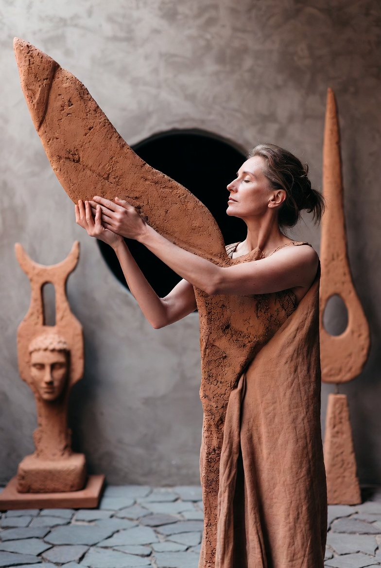 La Costruzione — fase 3 del metodo SLEGATA - Donna sulla cinquantina che emerge dall'argilla per ricostruirsi - Foto realizzata con xAI
